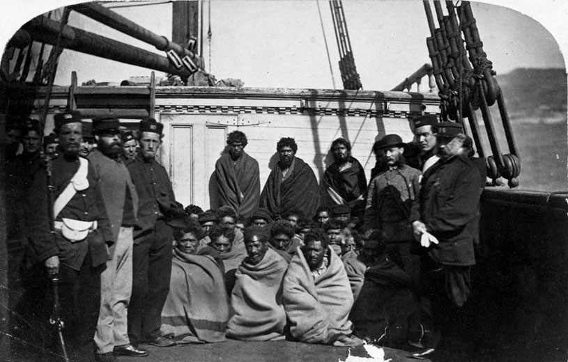 Māori prisoners who were members of the Hauhau church, under guard on board a prison hulk in Wellington harbour, 1866. Alexander Turnbull Library (1/2-103605F)