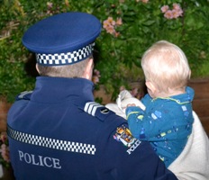 Officer carrying a young child.