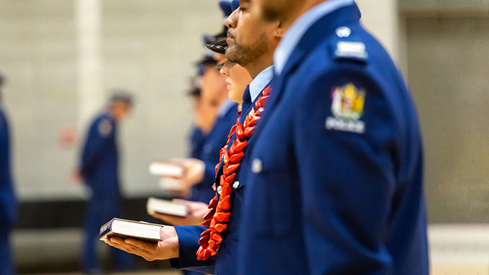 Photo showing a line of recruits, some of whom are holding a bible, during their attestation.