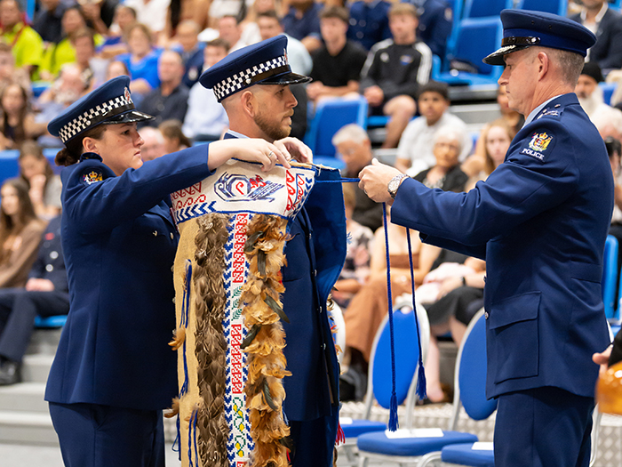 Constable James Bensley being presented with the korowai by Commissioner Andrew Coster