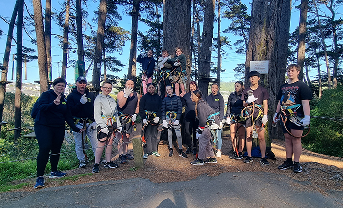 Group shot of the police staff, volunteers and young people taking part in the Blue Light Big Day Out at Adrenaline Forest.