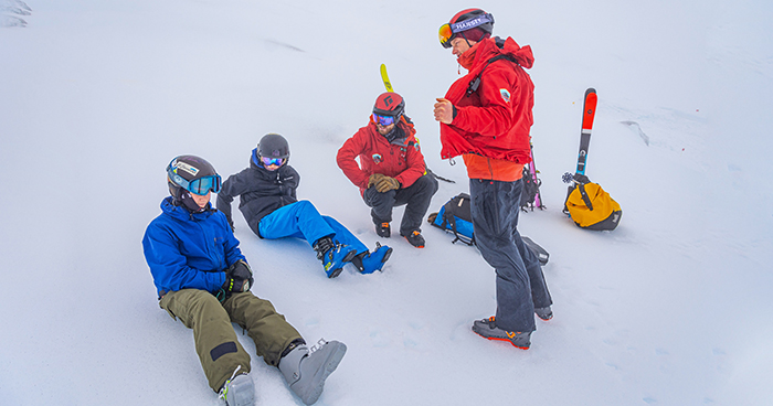 Four volunteers - three seated, one standing - take a moment on the mountain. PHOTO CREDIT: A Hoyle.