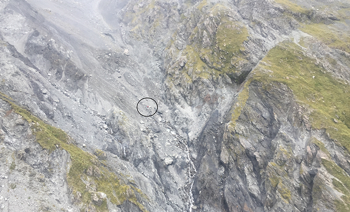 After finding footprints in the shingle, a check was undertaken of a nearby slope and a small bit of colour noticed, which turned out to be the tramper’s coat. A hand slowly raised in the air indicated he was alive