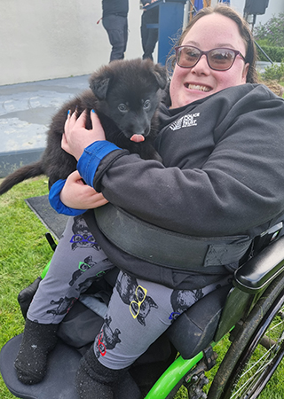 Natalya cuddling one of the Police puppies at the Dog Training Centre.