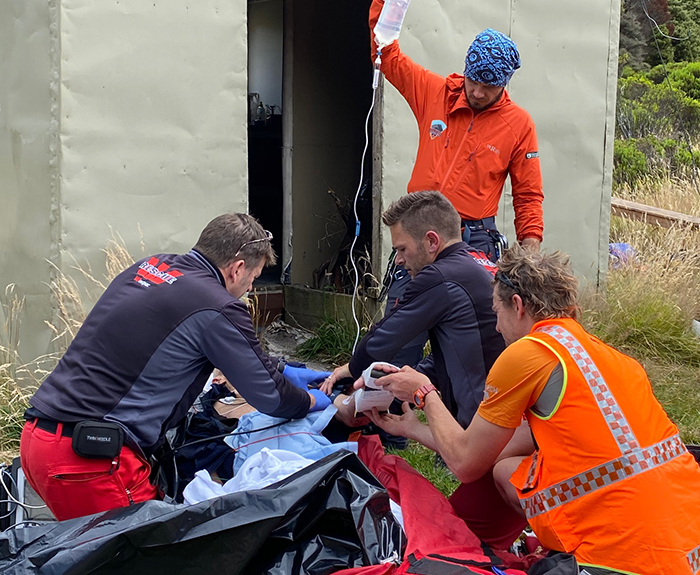Members of the Aoraki Mt Cook Alpine Cliff Rescue Team, Garden City Helicopters and Methven LandSAR administering first aid to the missing tramper.