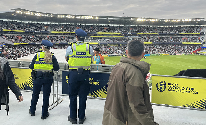 Shot from behind of Constables Hannah Green and Eddie Aufai looking out over the history-making crowd at Eden Park.