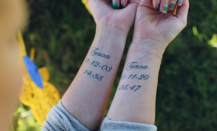 The tattoos on Rachel's forearms showing the times and dates of her son Tyson's birth and death.