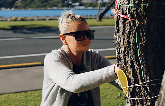 Tyson's mum, Rachel, tying something on to the tree where her son died.