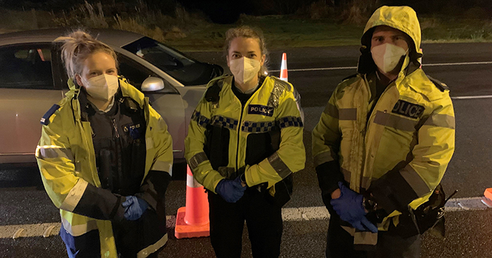 Constables Summer Pritchard and Sarah Stichbury, from Whanganui, and Jake Bone, from Marton, loving the weather at the Orams Road checkpoint.