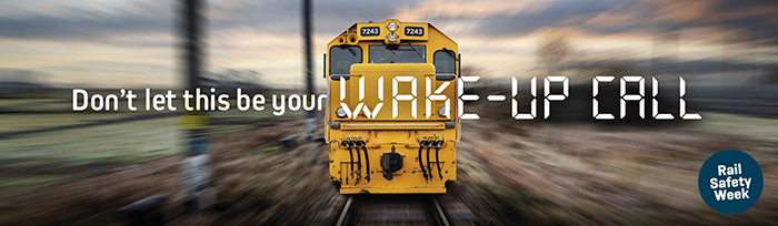 Rail safety week graphic of a photo of a train speeding towards you, with the words "Don't let this be your wake-up call" written across it.