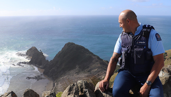 Senior Constable Leon Shepherd sat on rocks looking out to sea
