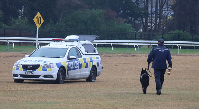 Senior Constable Billy Hill and Indo walking away from the camera towards their dog van.