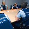 Police officers sitting around a table during a briefing.