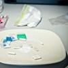 A variety of drugs sitting on a plate and in plastic bags.