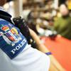 Photo showing police crest on arm of officer with store clerk blurred in the background