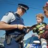 Officer taking notes with mother holding her child.