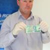 Acting Detective Sergeant Mike Freeman with one of the counterfeit notes.