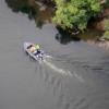 Rounding the corner: a Police helicopter flies over a search boat on the Waikato River