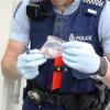 An officer inspects medication recovered in the operation