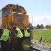 Police and Kiwi Rail staff check damage to the train