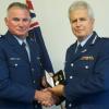 Commissioner Peter Marshall presents the Meritorious Service Medal to Sergeant Terry Johnson