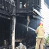 A fire-fighter dampens down hotspots inside the scene of Saturday's fire