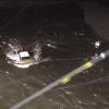 Rescue teams working to bring the pair safely ashore after vehicle becomes stuck in water.
