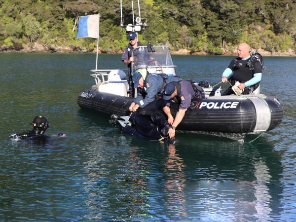 The missing diver' - in the shape of a Navy mannequin - is recovered.
