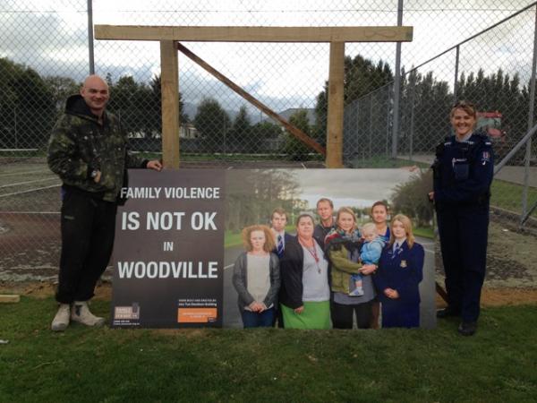 Pahiatua builder Joss Tua-Davidson and Tararua Family Violence Intervention Coordinator Constable Maxine Walshe install the Woodville billboard.