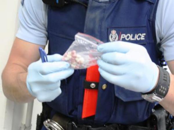 An officer inspects medication recovered in the operation