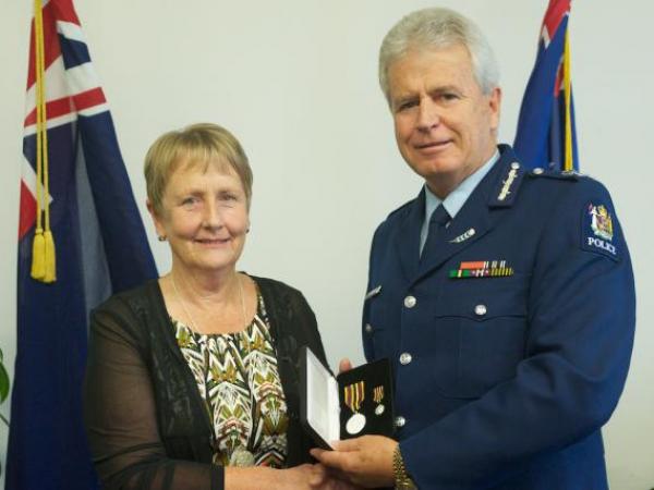 Commissioner Peter Marshall presents the Meritorious Service Medal to Anne Routledge