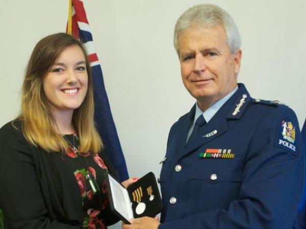 Commissioner Peter Marshall presents the Meritorious Service Medal to Kate Wilson, who received the award on behalf of her father, the late Superintendent Mike Wilson