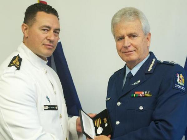 Commissioner Peter Marshall presents the Meritorious Service Medal to Joe Catterall, who received the award on behalf of his uncle, the late Sergeant Paddy Whiu