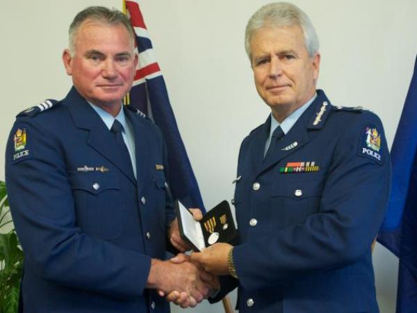 Commissioner Peter Marshall presents the Meritorious Service Medal to Sergeant Terry Johnson
