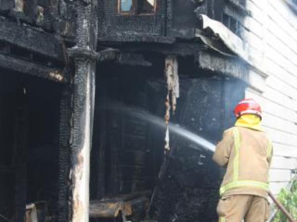 A fire-fighter dampens down hotspots inside the scene of Saturday's fire