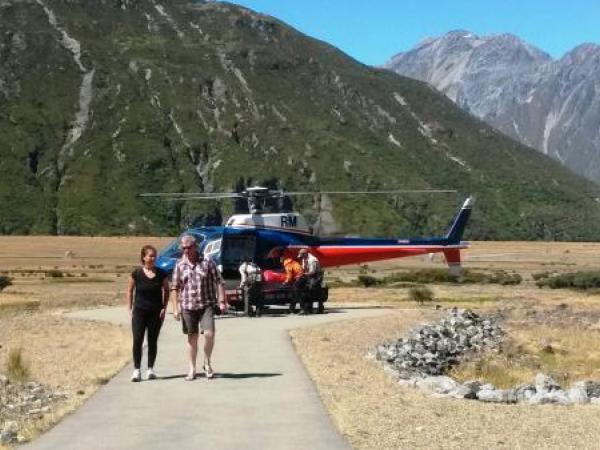 Rescued hiker (dressed in black) being escorted to Aoraki Mt Cook Emergency Centre
