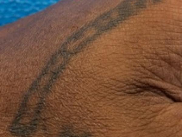 This tattoo is on the dead man's hand.