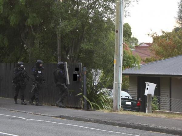 Members of the Waikato Armed Offenders Squad approach an Ellicott Rd address