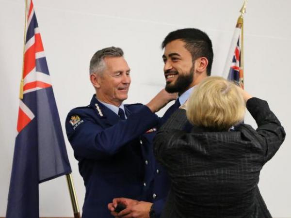 Commissioner Mike Bush and Carolyn Tremain change Wing 319 Constable Richard Paku's epaulettes from recruit to constable