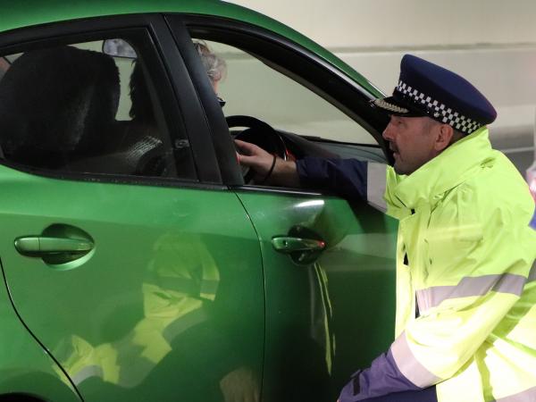 A police officer speaks to a motorist at a checkpoint. 