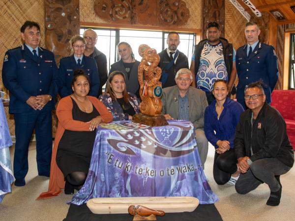 Police and partners gather around the Te Pai Oranga pou.