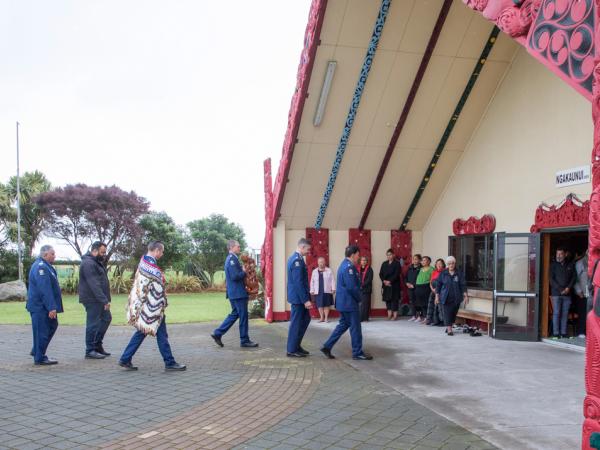 The manuhiri approach and enter Te Ngakaunui, the meeting house at Aotearoa Marae.