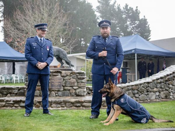 Constable Andrew Smart and Talon at graduation watched on by Sergeant Scott Robinson