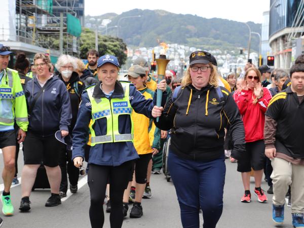 Police staff member and Special Olympics representative carry the torch 