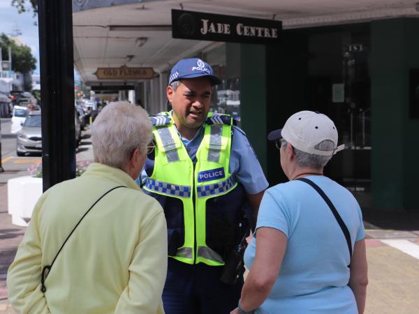 Sergeant Philip Rowden speaks with two tourists in Napier CBD