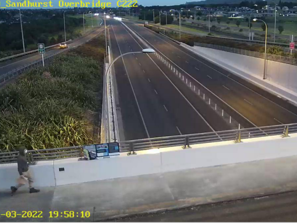 Man walking on Sandhurst Drive overbridge 