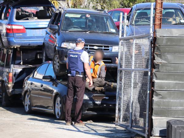 Police speak with a person at the yard in Christchurch.