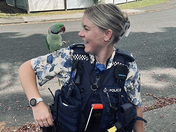 Detective Constable Jaime with a parakeet on her shoulder. 