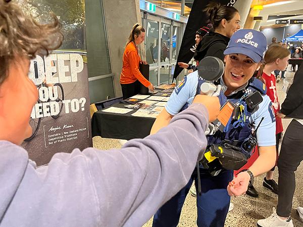 A female police officer encouraging someone as they try out the grip test.