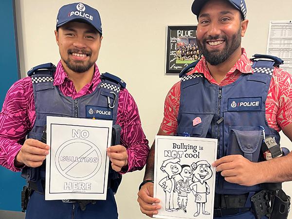Two officers incorporating pink into their uniforms for Pink Shirt Day 2024.